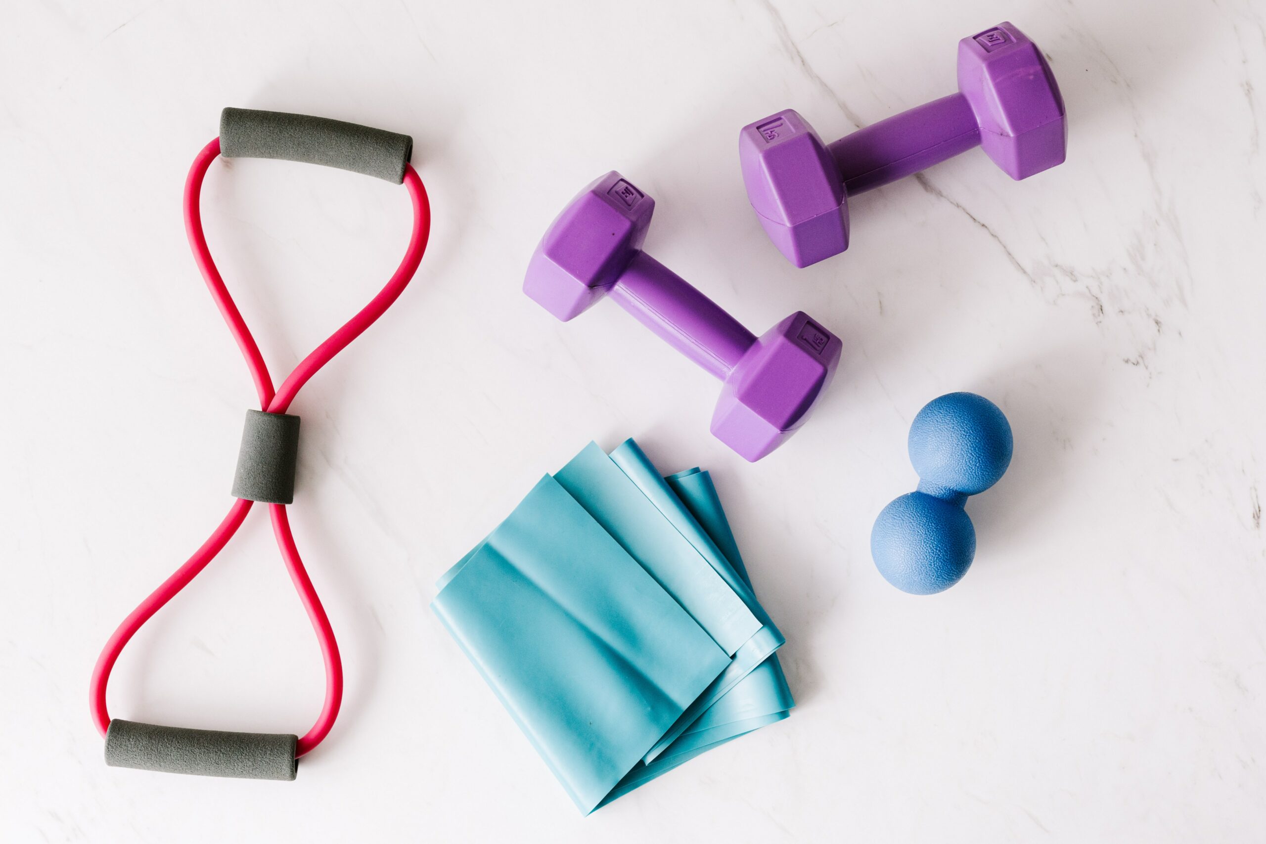 A Flat Lay of Fitness Equipment Including a Red Resistance Band